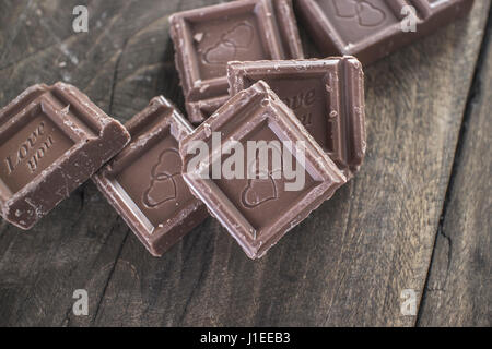 Pieces of  chocolate on wooden background, from above Stock Photo
