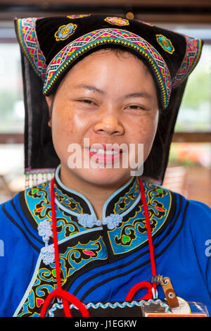 Guizhou, China.  Young Han Chinese Woman in Bouyei Dress, working in a Roadside Rest Stop. Stock Photo