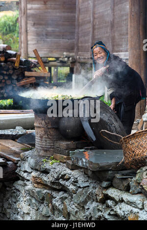 Huanggang, Guizhou, China.  Dong Women Cooking Greens for Pig Food. Stock Photo