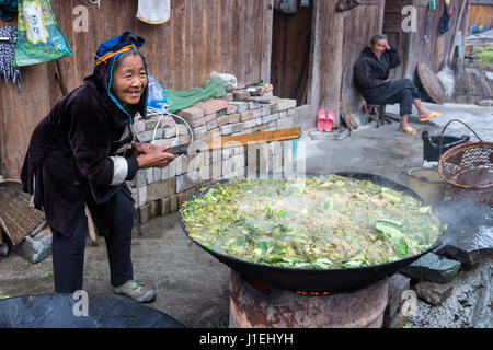 Huanggang, Guizhou, China.  Dong Women Cooking Greens for Pig Food. Stock Photo