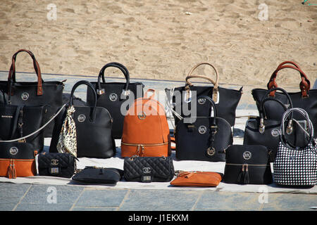 BARCELONA/SPAIN - 15 APRIL 2017: False branded leather bags such as Michael Kors and Chanel sold on Barceloneta beach Stock Photo