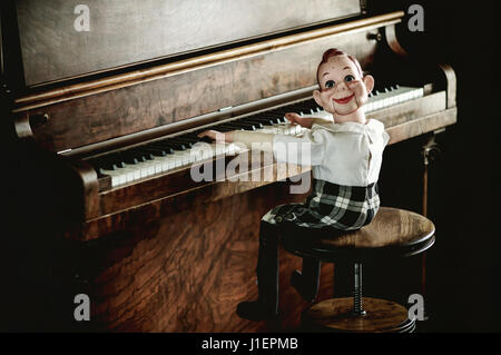 Howdy Doody ventriloquist doll sitting at an upright piano. Stock Photo