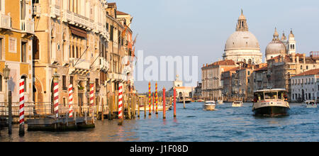 Venice Grand Canal view from Ponte dell'accademia Bridge of vaporetto water bus with church of Santa Maria della Salute in evening sunshine Stock Photo