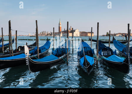 Gondolas moored on waterfront of St Marks square with island and church of San Giorgio Maggiore in background, Venice Stock Photo