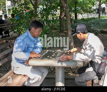 Men playing chinese chess in Columbus park in Chinatown, NYC Stock Photo