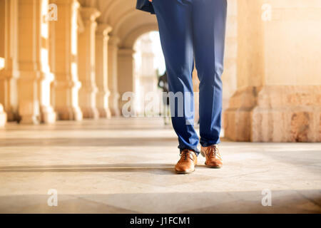 Detail of man's legs, while he is walking in the street Stock Photo