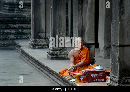 Buddhist monk sells prayers in the Angkor Wat temple complex in Siem Reap, Cambodia. Stock Photo