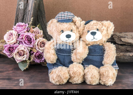 Two teddy bears holding hand and take a photo in studio over flower background, love and friendship concept Stock Photo