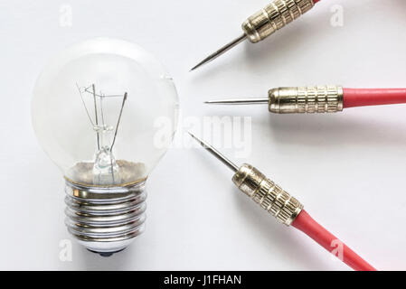 Closeup bulb lamp with three dart on white background, idea and business success concept Stock Photo