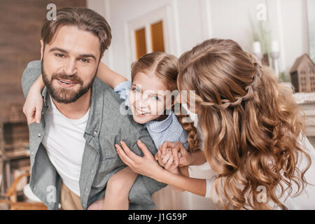 Father piggybacking happy daughter. Family having fun at home Stock Photo