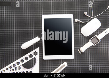 Top view of digital tablet with blank screen, smartwatch, computer mouse, earphones and office supplies on black Stock Photo