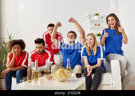 friends or football fans watching soccer at home Stock Photo