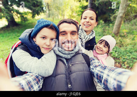 family with backpacks taking selfie and hiking Stock Photo