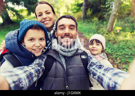 family with backpacks taking selfie and hiking Stock Photo