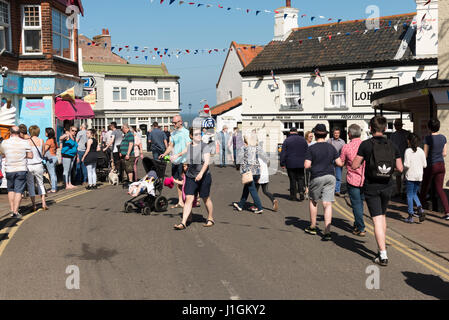 People walking in the street in Sheringham Norfolk, a seaside town in the UK on a sunny spring day Stock Photo