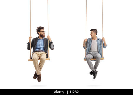 Father and son sitting on swings and looking at each other isolated on white background Stock Photo