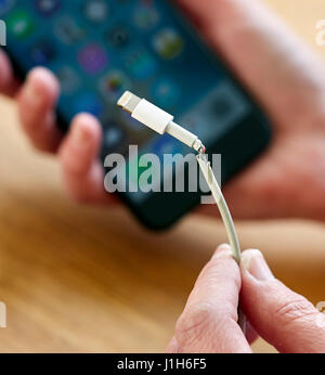 Broken iPhone charging lead Stock Photo