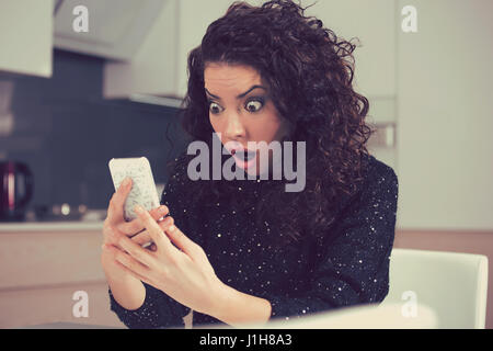 Closeup portrait funny shocked anxious woman looking at phone seeing bad photos message with scared emotion on face Stock Photo