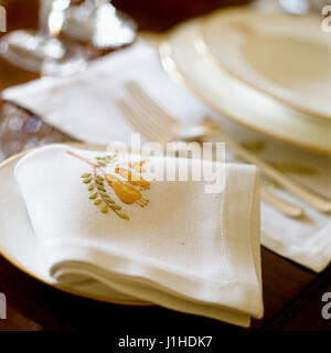 White place setting with embroidered napkin. Stock Photo