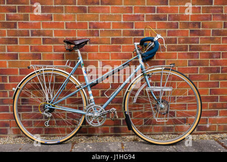 Classic custom built ladies Mercian traditional touring bicycle bike with leather Brookes saddle drop handlebars leaning up against a brick wall. UK Stock Photo