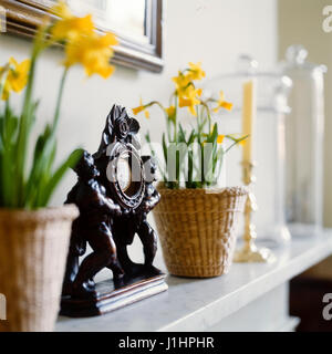 Clock and flowers on mantelpiece. Stock Photo