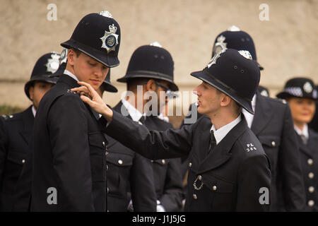 New Metropolitan Police officers check their uniforms before taking part in their passing-out parade at the Police Academy in Hendon, London. Stock Photo