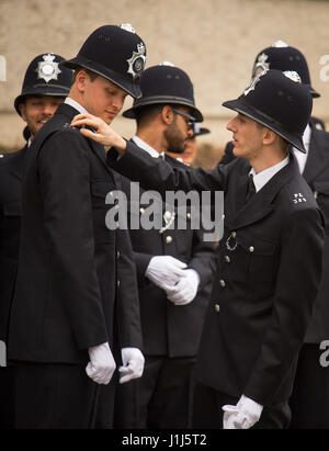 New Metropolitan Police officers check their uniforms before taking part in their passing-out parade at the Police Academy in Hendon, London. Stock Photo