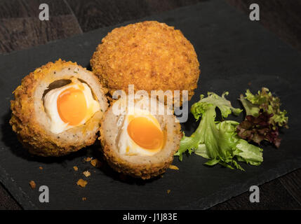 Runny Scotch eggs on a cutting board Stock Photo