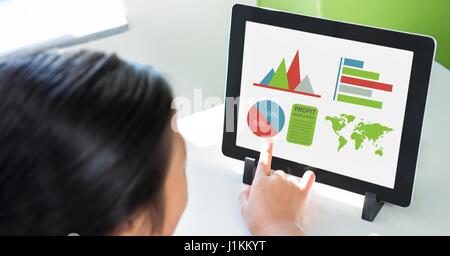 Digital composite of Cropped image of person using digital tablet with various graphs and charts on screen at table Stock Photo
