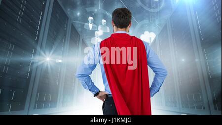 Digital composite of Back of business man superhero with hands on hips against servers with flares Stock Photo