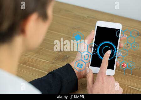 Digital composite of Businesswoman using IOT graphics on smart phone Stock Photo