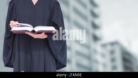 Digital composite of Judge holding book in front of buildings Stock Photo