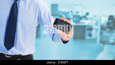 Digital composite of Midsection of businessman showing blank screen on mobile phone Stock Photo