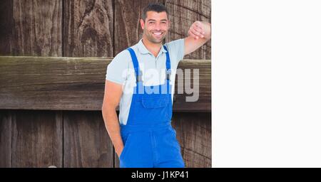 Digital composite of Confident worker leaning on blank bill board Stock Photo
