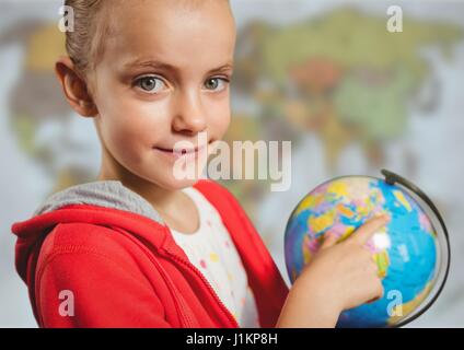 Digital composite of Girl with globe against blurry map Stock Photo