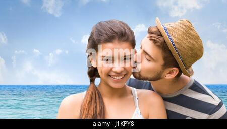 Digital composite of Loving man kissing woman on at beach Stock Photo