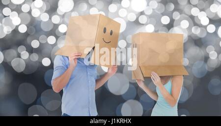 Digital composite of Couple with emojis on cardboard boxes over bokeh background Stock Photo