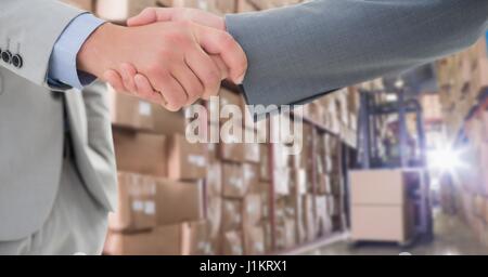 Digital composite of Cropped image of businessmen doing handshake in warehouse Stock Photo