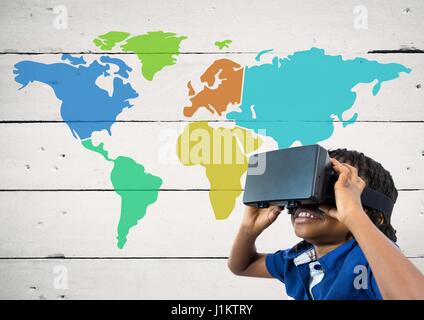 Digital composite of Boy with VR headset next to Colorful Map with paint splatters on wood background Stock Photo