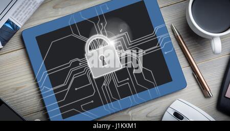 Digital composite of Tablet on table with white lock graphic and flare Stock Photo