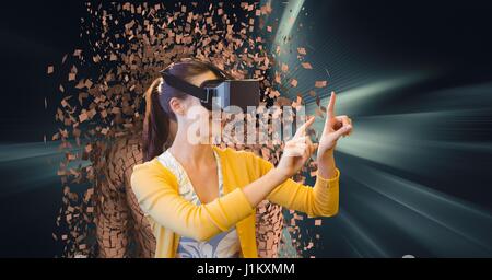 Digital composite of Woman wearing VR glasses with 3d scattered human figure in background Stock Photo