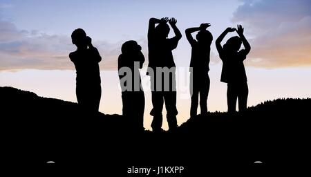 Digital composite of Silhouette children on hill against sky Stock Photo