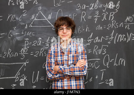 Boy and blackboard filled with math formulas Stock Photo