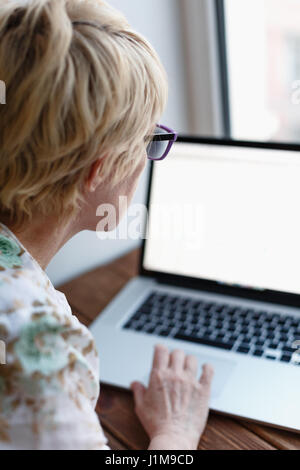 Back view of woman using laptop Stock Photo