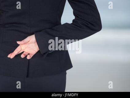 Digital composite of Woman fingers crossed, blurred background Stock Photo