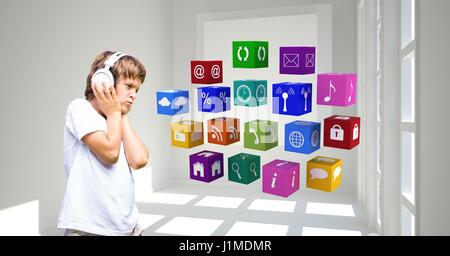 Digital composite of Boy listening to music through headphones while looking at apps icons Stock Photo