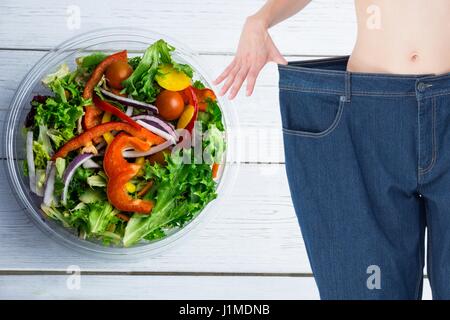 Digital composite of Composite image of midsection of woman measuring waist Stock Photo