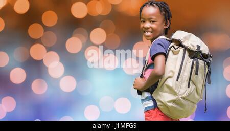 Digital composite of Rear view of school child carrying backpack over bokeh Stock Photo