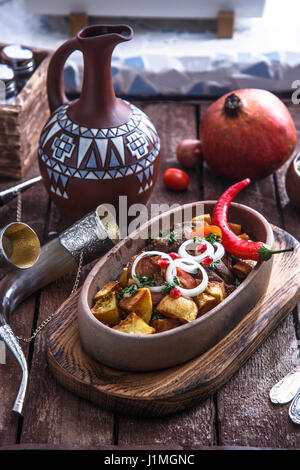 Ojaxuri, roasted pork and potatoes with onion and pomegranate seeds. Top view Stock Photo