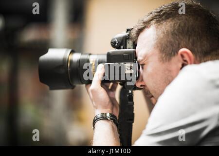 Studio Photographer in Action. Caucasian Photographer Taking Picture Using Professional Photo Gear. Stock Photo